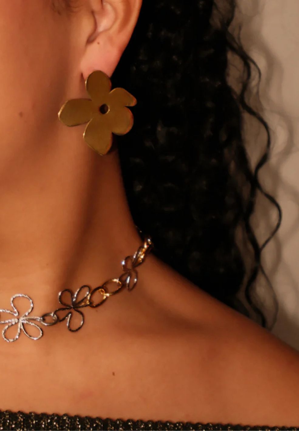 Bloomed Necklace: Mixed metal chain with open gold and silver flower pendants, worn on a model.