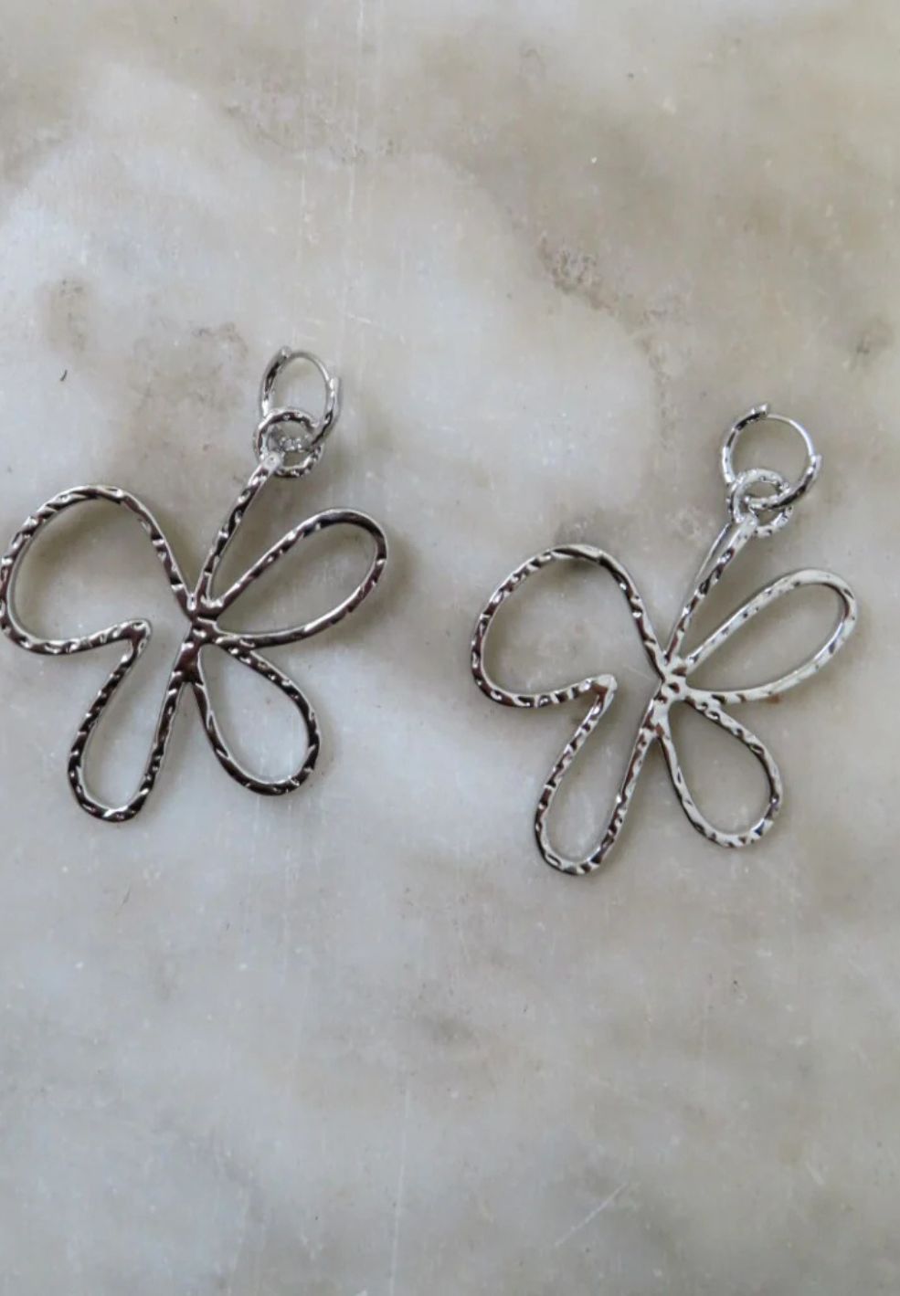 Pair of silver stainless steel Bloomed Earrings, abstract butterfly design with hammered finish.